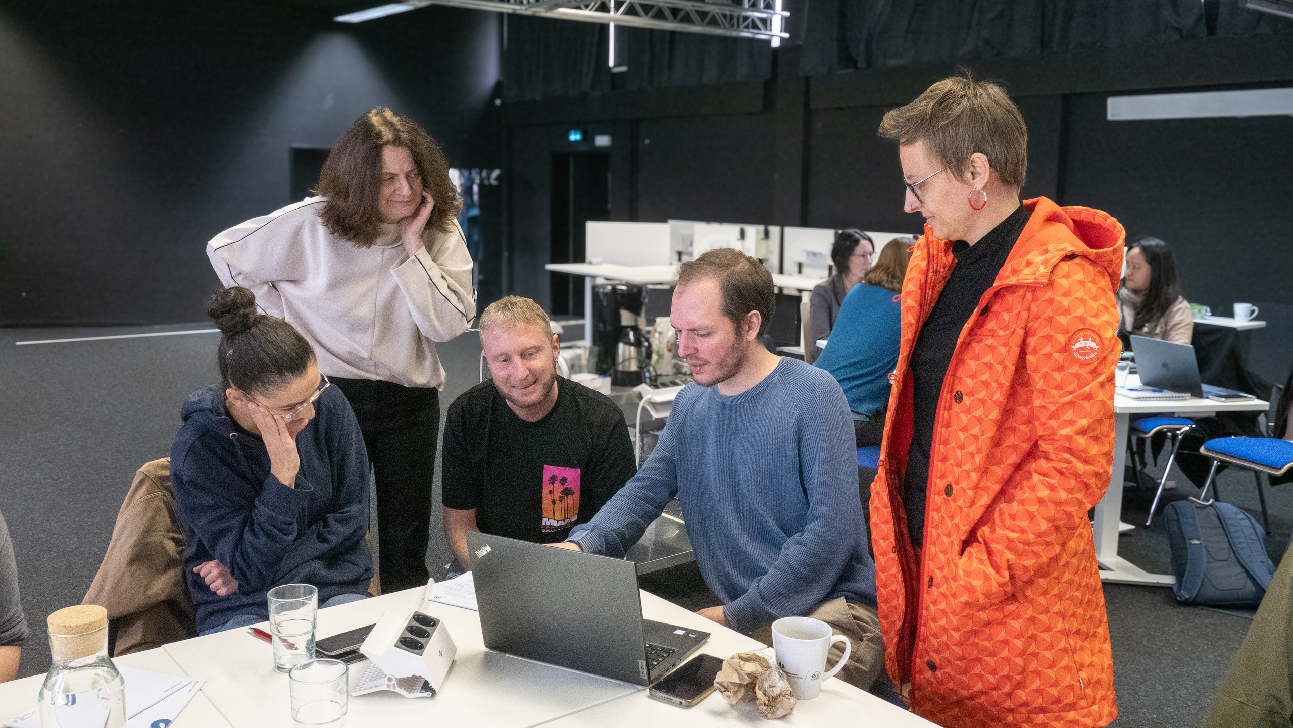 Die Teilnehmenden arbeiten in Gruppenarbeiten an Tischen